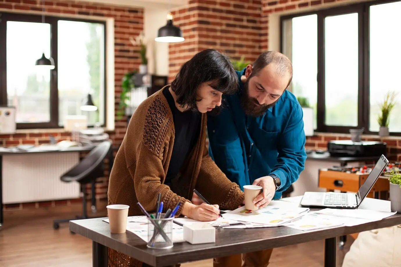 Ein Mann und eine Frau prüfen Unterlagen in einem Büro.